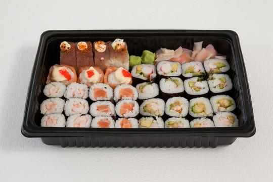 一套什锦寿司放在白底黑盒子里