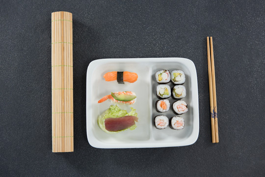 用筷子将寿司放在托盘上