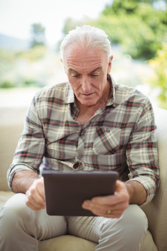 老年人在家客厅使用数字平板电脑