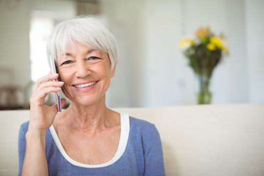 老年妇女在家里里用手机说话