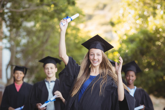 研究生院学生站在校园拿学位卷轴