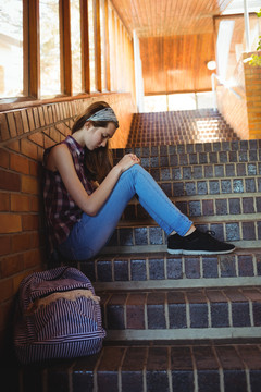 独自坐在学校的楼梯上的女学生