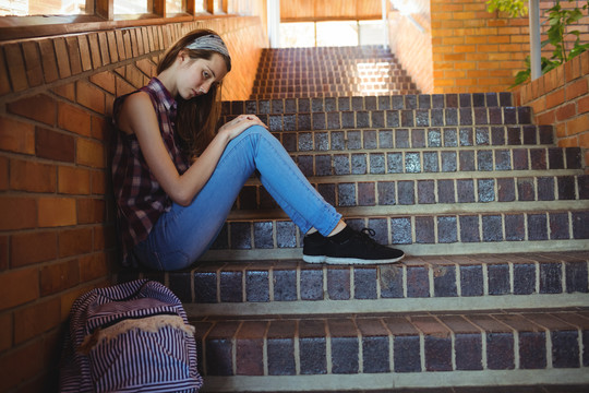 独自坐在学校的楼梯上的女学生