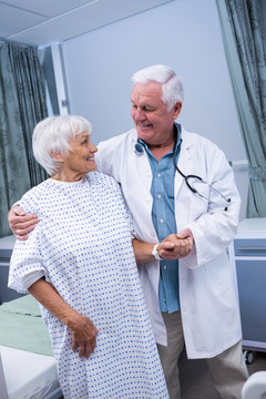 微笑医生在医院协助老年病人