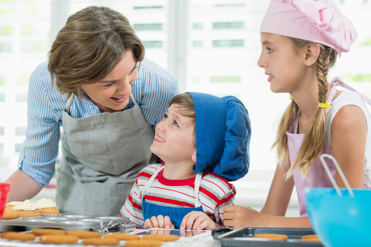 微笑的母亲和孩子在厨房准备饼干
