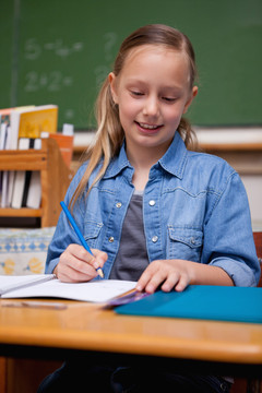 一个快乐的女学生在教室里写字