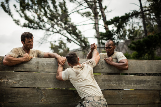 士兵们在新兵训练营爬上木墙