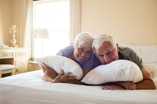 老年夫妇在卧室的床上吃早餐