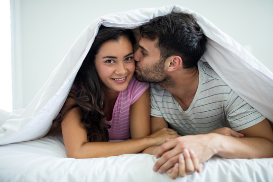 家里卧室毛毯下幸福夫妻的画像
