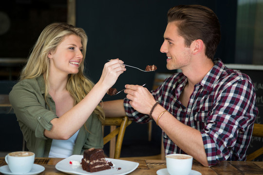 年轻夫妇在自助餐厅吃甜点
