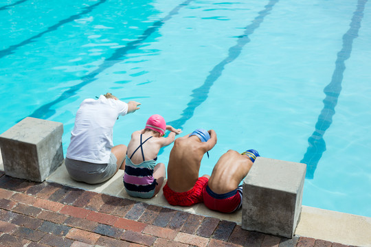 女游泳教练与学生在泳池边