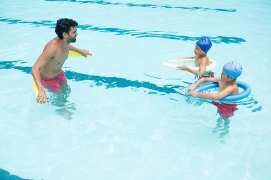 教练和孩子在泳池玩耍