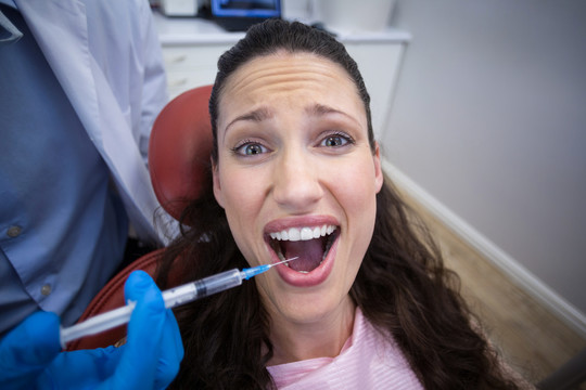 牙科医生帮助女患者拔牙