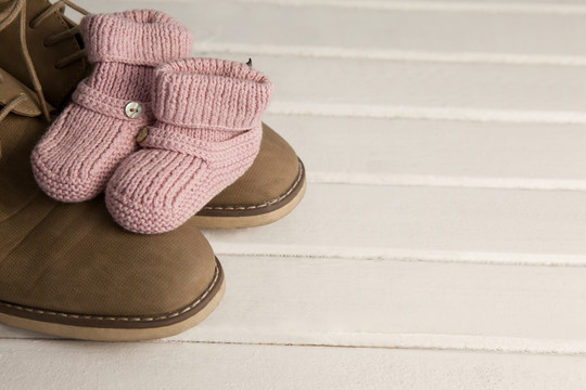木地板上婴儿靴和男鞋