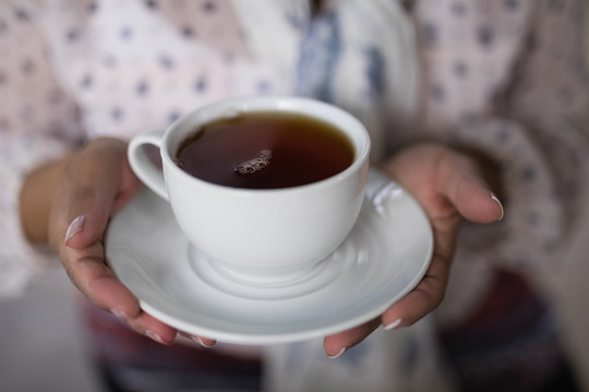 妇女在家拿茶杯的中段