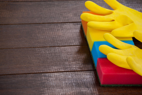 用木地板上的擦洗垫封闭黄色手套