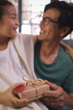 女儿在客厅给父亲送礼物盒