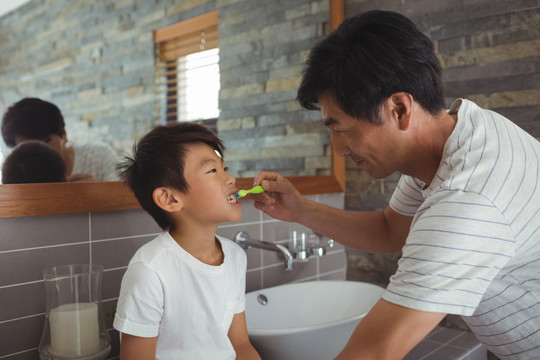 父亲在浴室给儿子刷牙