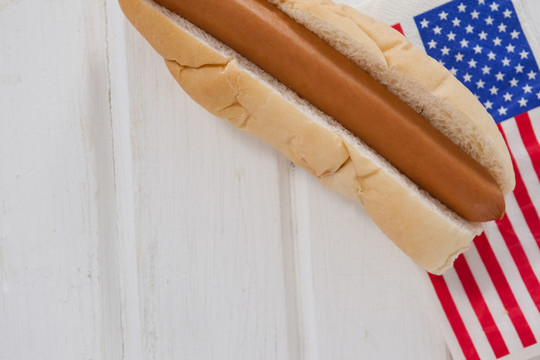 白木桌上的热狗和美国国旗
