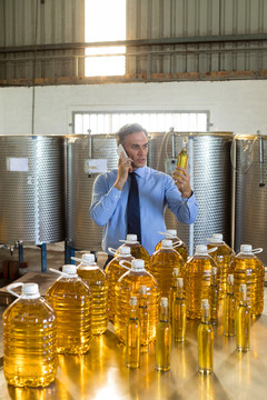经理检查橄榄油时用手机说话