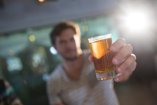 酒吧里拿啤酒杯的男人