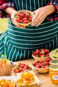 在农场卖草莓和西红柿的妇女