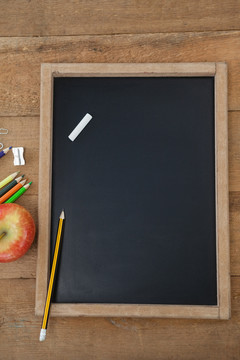 学校用品和木制桌子上的苹果