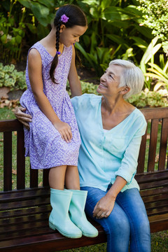 奶奶和孙女坐在木凳上