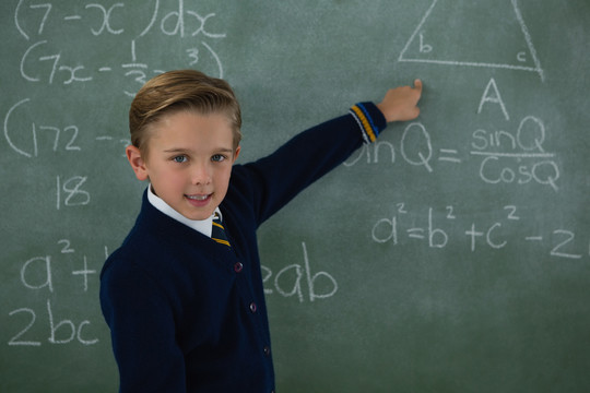 小学生在黑板上解数学公式