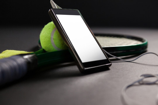 用网球拍特写手机和耳机