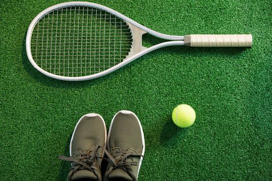球拍与鞋子和网球的特写镜头