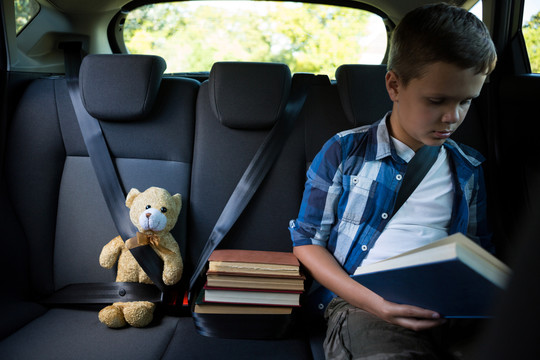 十几岁的男孩在车里看书