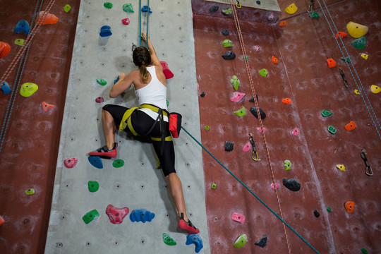 在健身室练习攀岩的女性