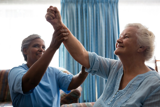 护士帮助老年妇女锻炼肌肉