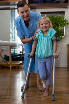 理疗师协助女患者拐杖行走