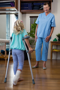 理疗师协助女患者拐杖行走