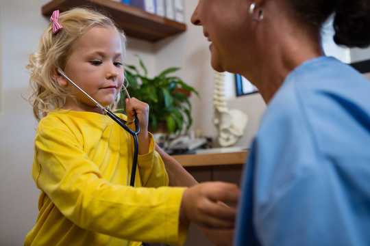 小女孩在医院使用听诊器