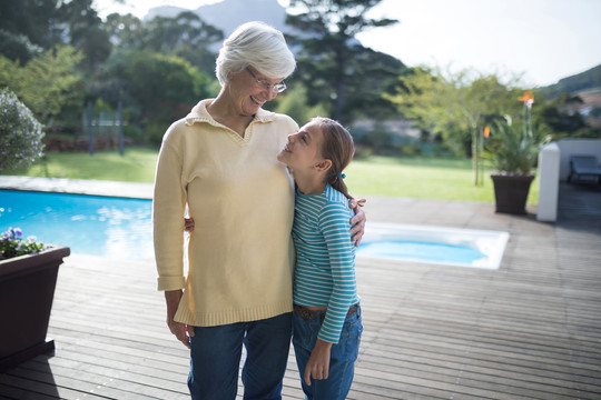 孙女和祖母在游泳池旁拥抱