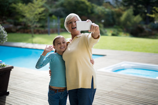 孙女和祖母在泳池边自拍
