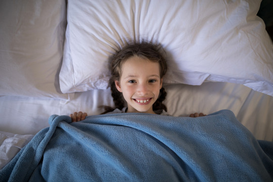 微笑的女孩躺在卧室的床上