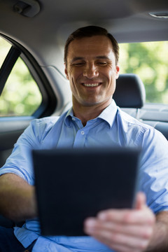 在车上使用电脑的微笑男人