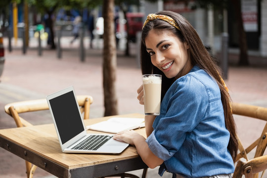 坐在咖啡店时使用电脑的女人