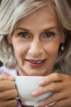 咖啡馆坐着咖啡杯的老妇人