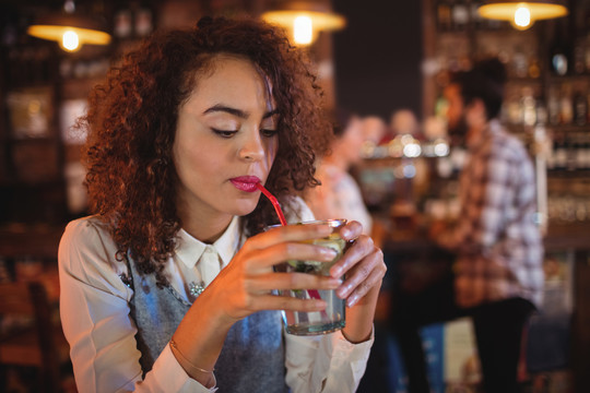 酒吧里喝红酒的年轻女人