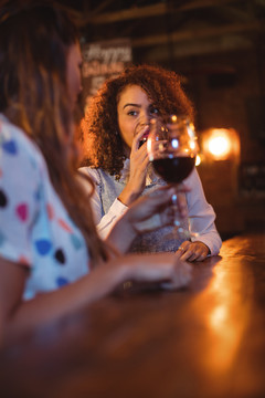 酒吧里喝红酒的年轻女人