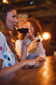 酒吧里喝红酒的年轻女人