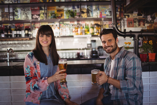 酒吧柜台端着啤酒的幸福夫妻画像