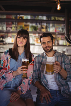 酒吧柜台端着啤酒的幸福夫妻画像