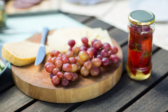 木桌上用罐子盛奶酪的葡萄