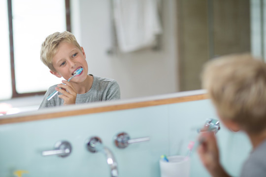 男孩在家里的浴室刷牙